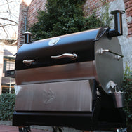 The RT-2500 BFG wood pellet grill turned sideways and next to a brick home.