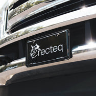 Black aluminum license plate with recteq logo in white on a truck.